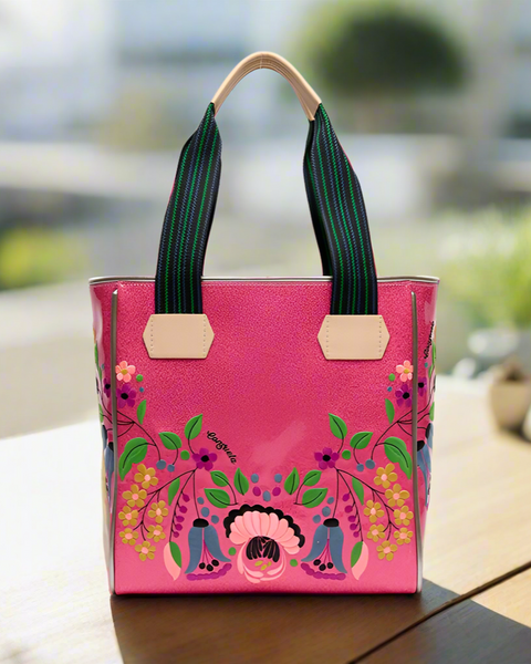 Pink handbag with floral  design on a blurred background