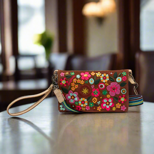 Colorful floral embroidered handbag on a table with a blurred indoor background