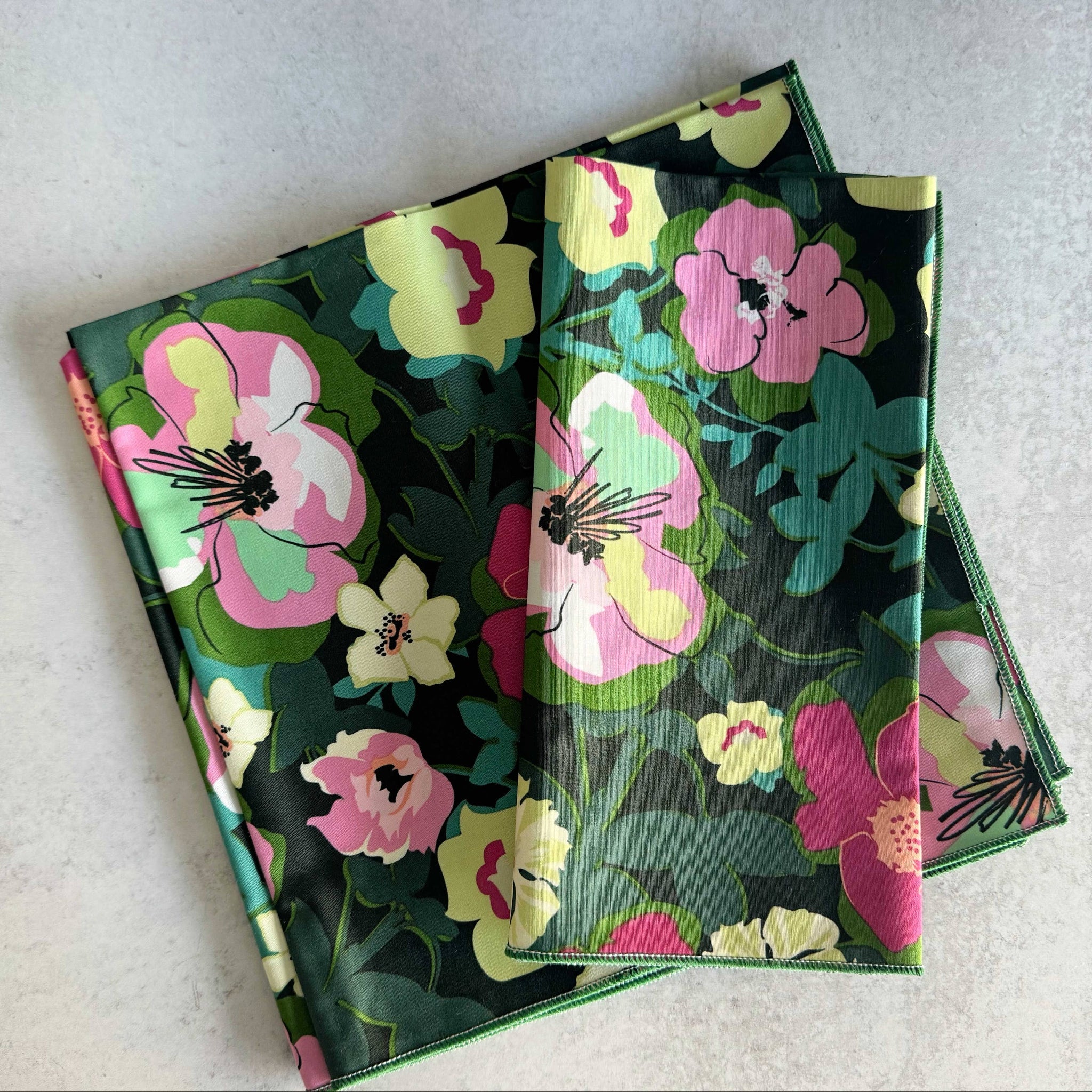 Two floral-patterned notebooks stacked on a light gray surface