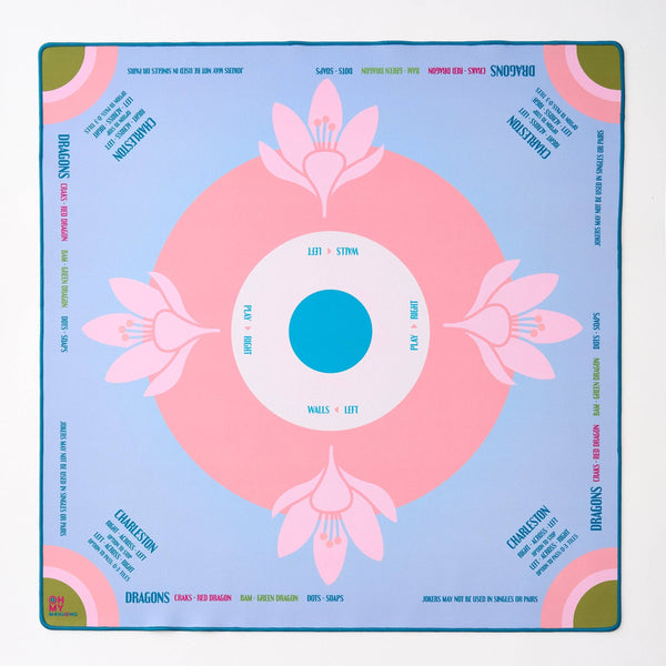 Decorative mahjong mat with pink floral design on a blue background
