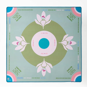 Decorative mahjong mat with floral design on a light sage blue background