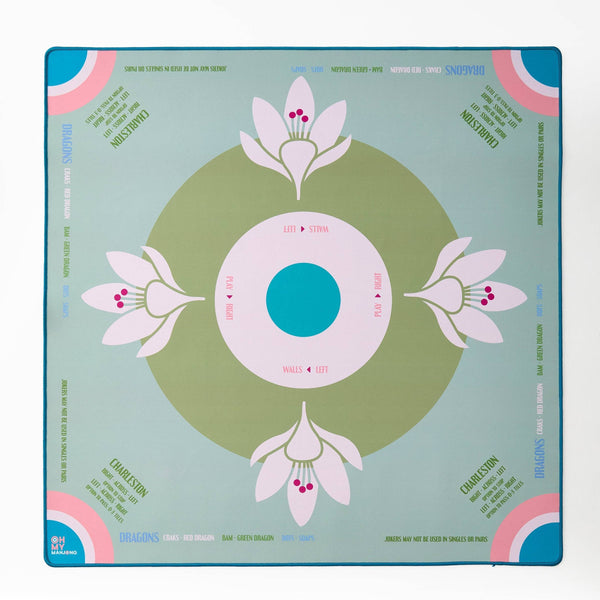 Decorative mahjong mat with floral design on a light sage blue background
