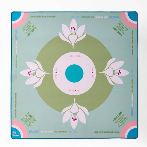 Decorative mahjong mat with floral design on a light sage blue background