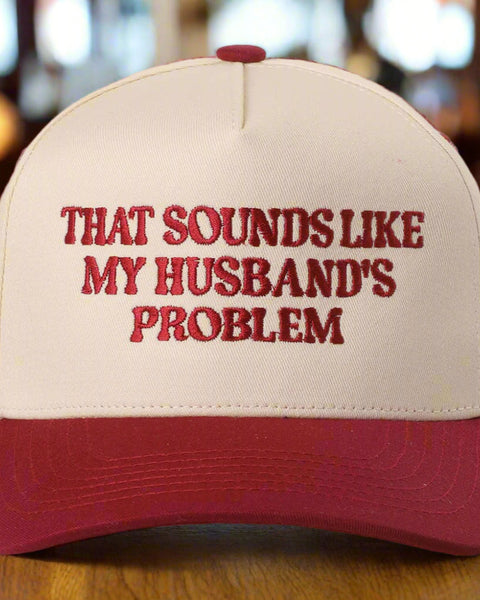 Beige and red cap with text 'That sounds like my husband's problem' on a light gray background